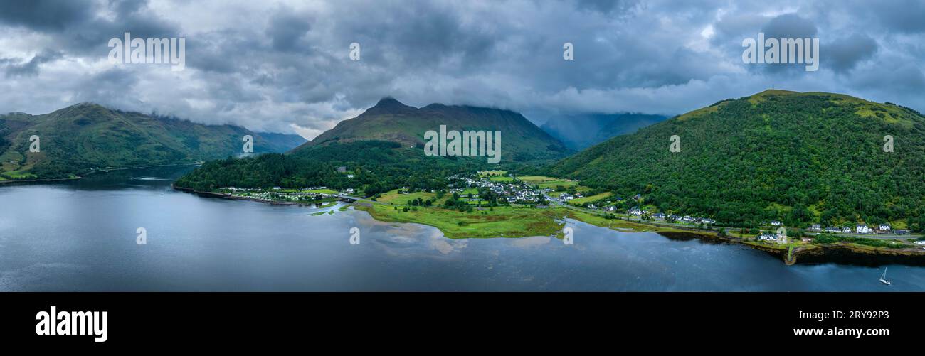 Panorama aereo del lago d'acqua dolce loch Leven con il villaggio di Glen Coe, sopra di esso, il Pap of Glencoe, Highlands, Scozia, alto 742 metri Foto Stock