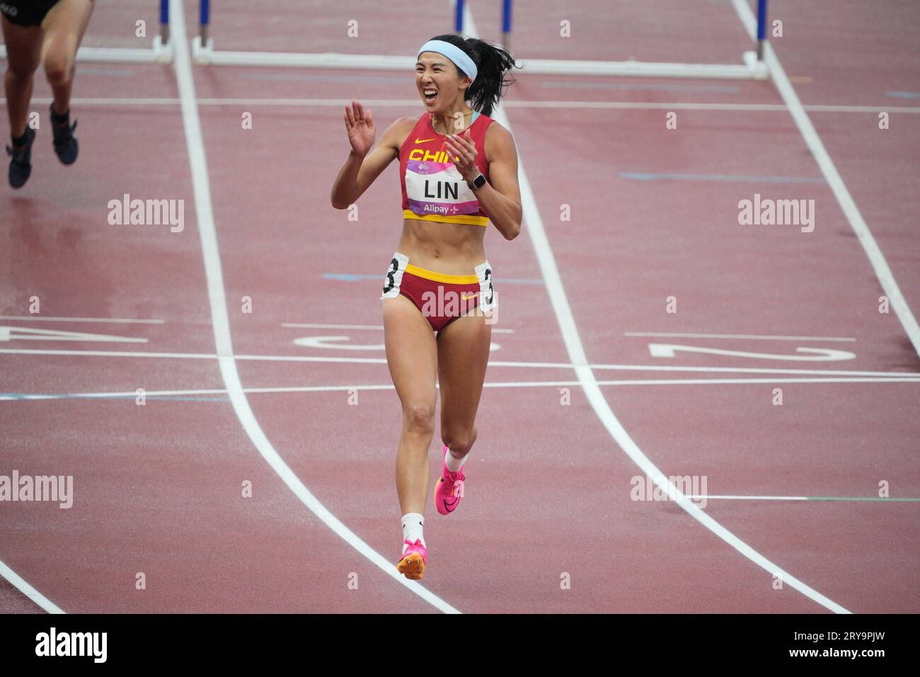China's Lin Yuwei reacts after finishing first during the women's 100-meter hurdle heat 1 at the 19th Asian Games in Hangzhou, China, Saturday, Sept. 30, 2023. (AP Photo/Vincent Thian) Foto Stock