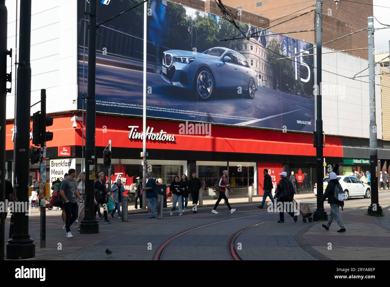 Ristorante Tim Hortons con pubblicità per veicoli elettrici BMW I5. Market Street, Manchester, Regno Unito Foto Stock