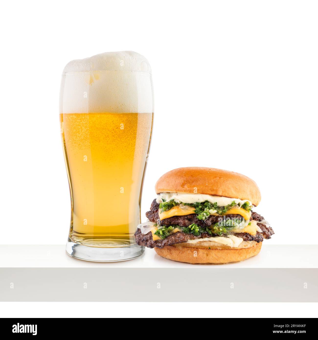 Pinta di birra lager con hamburger classico su scaffale bianco. Foto Stock