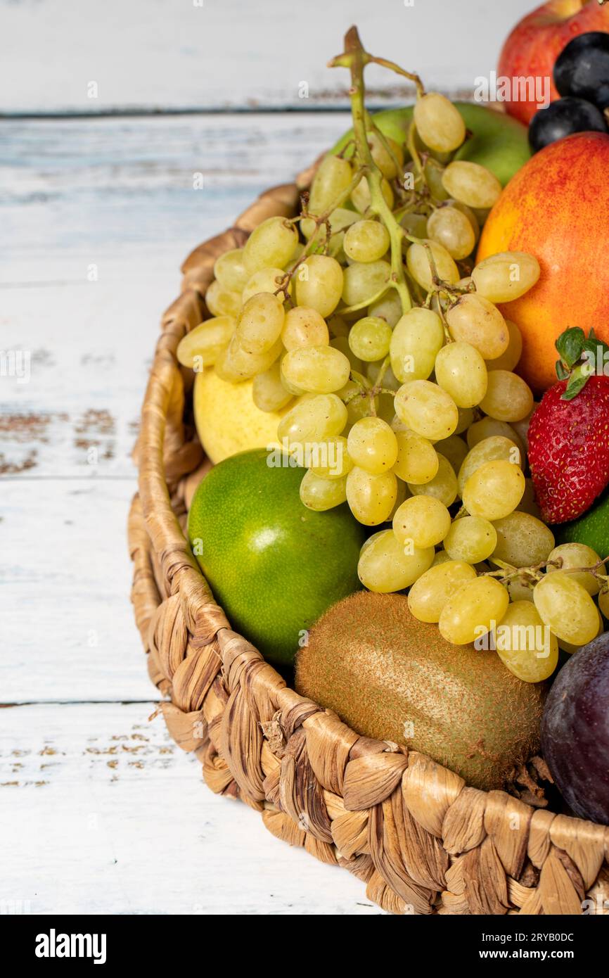 Frutta fresca in un cestino di vimini. Frutta variopinta. Vista verticale. Primo piano Foto Stock
