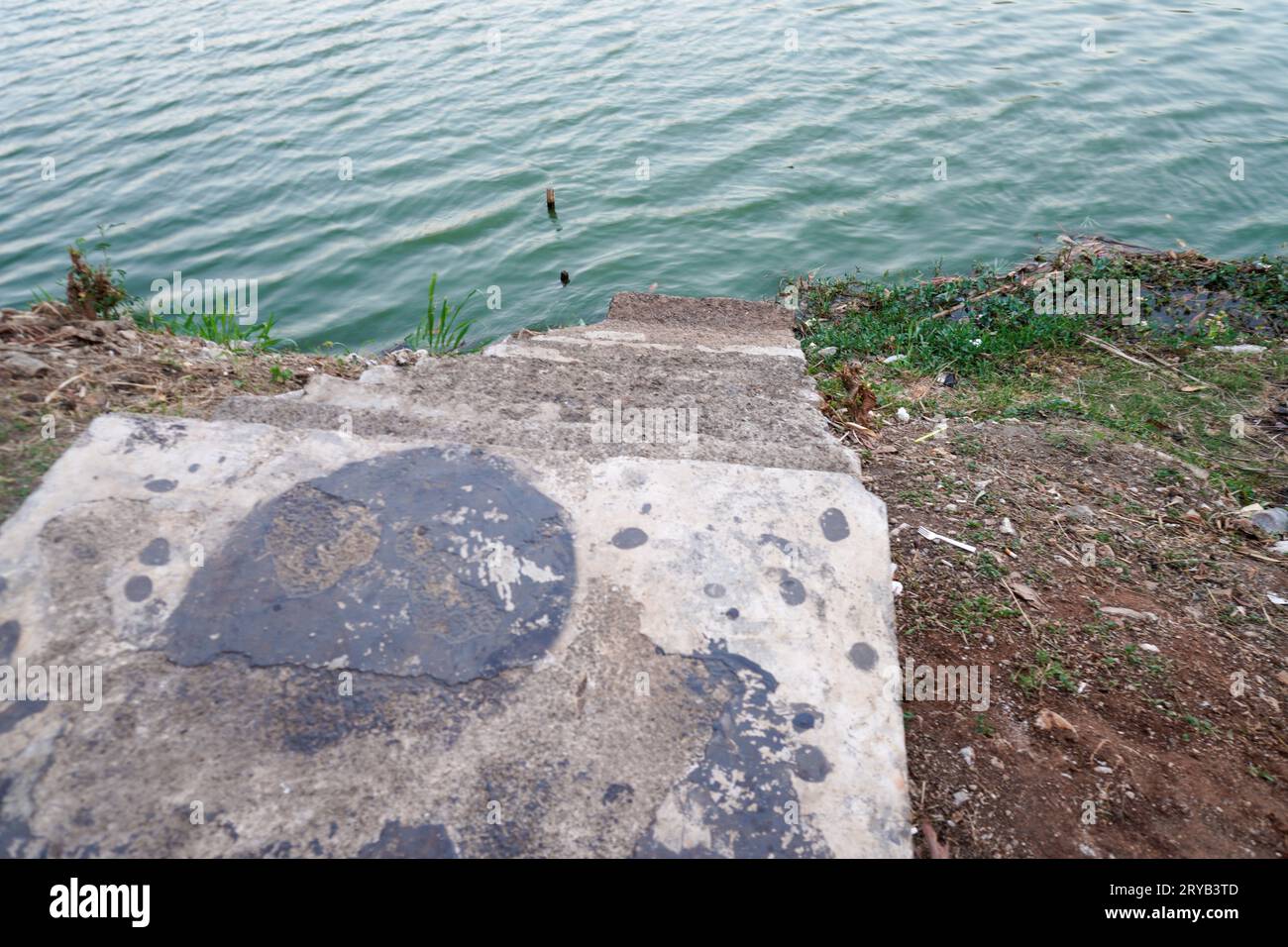 I gradini che conducono al lago sono fatti di cemento con terreno rosso intorno ad esso. visto dall'alto. Foto Stock