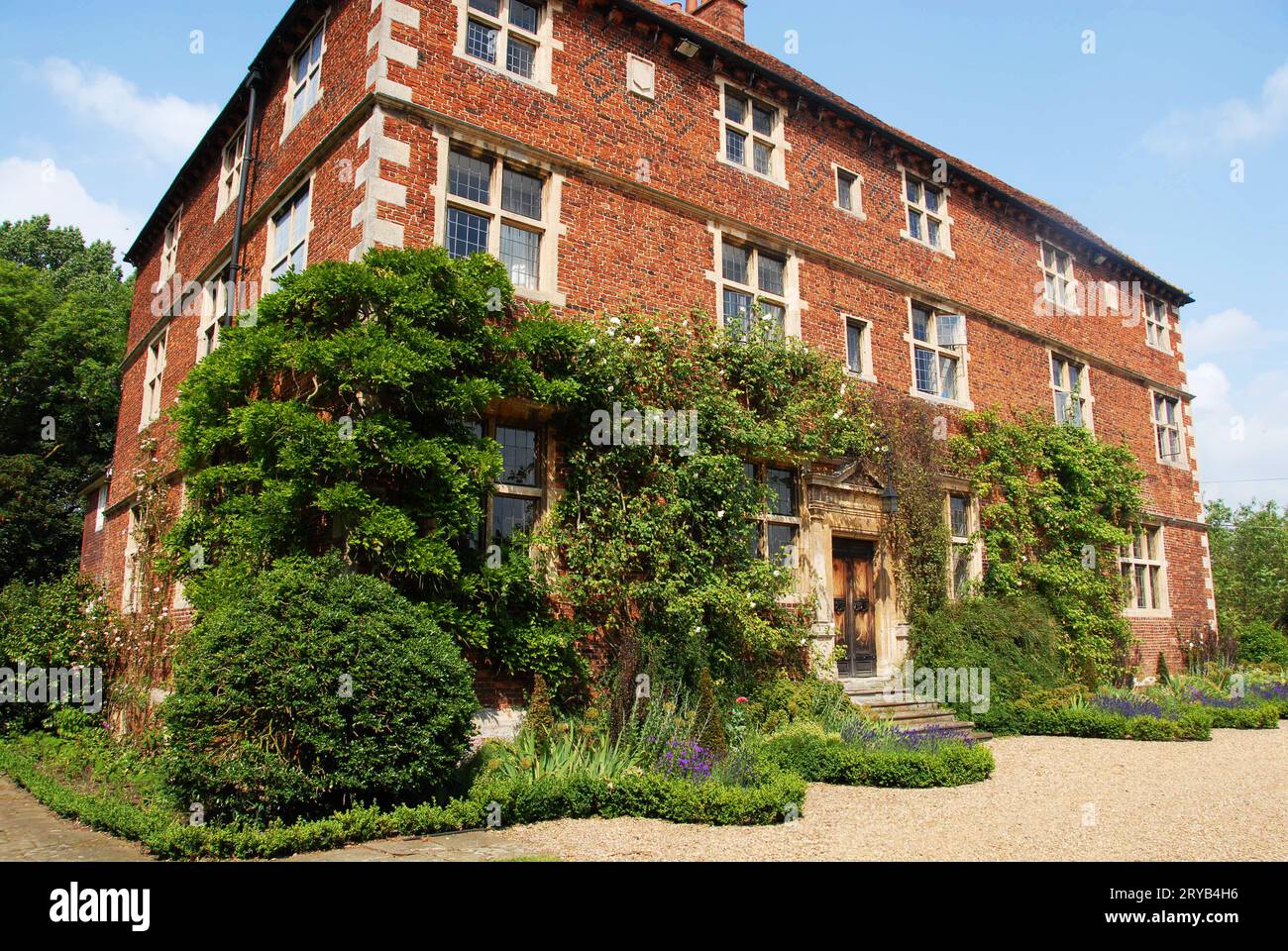 Una vista d'inizio estate di Aubourn Hall con rose per arrampicarsi Foto Stock