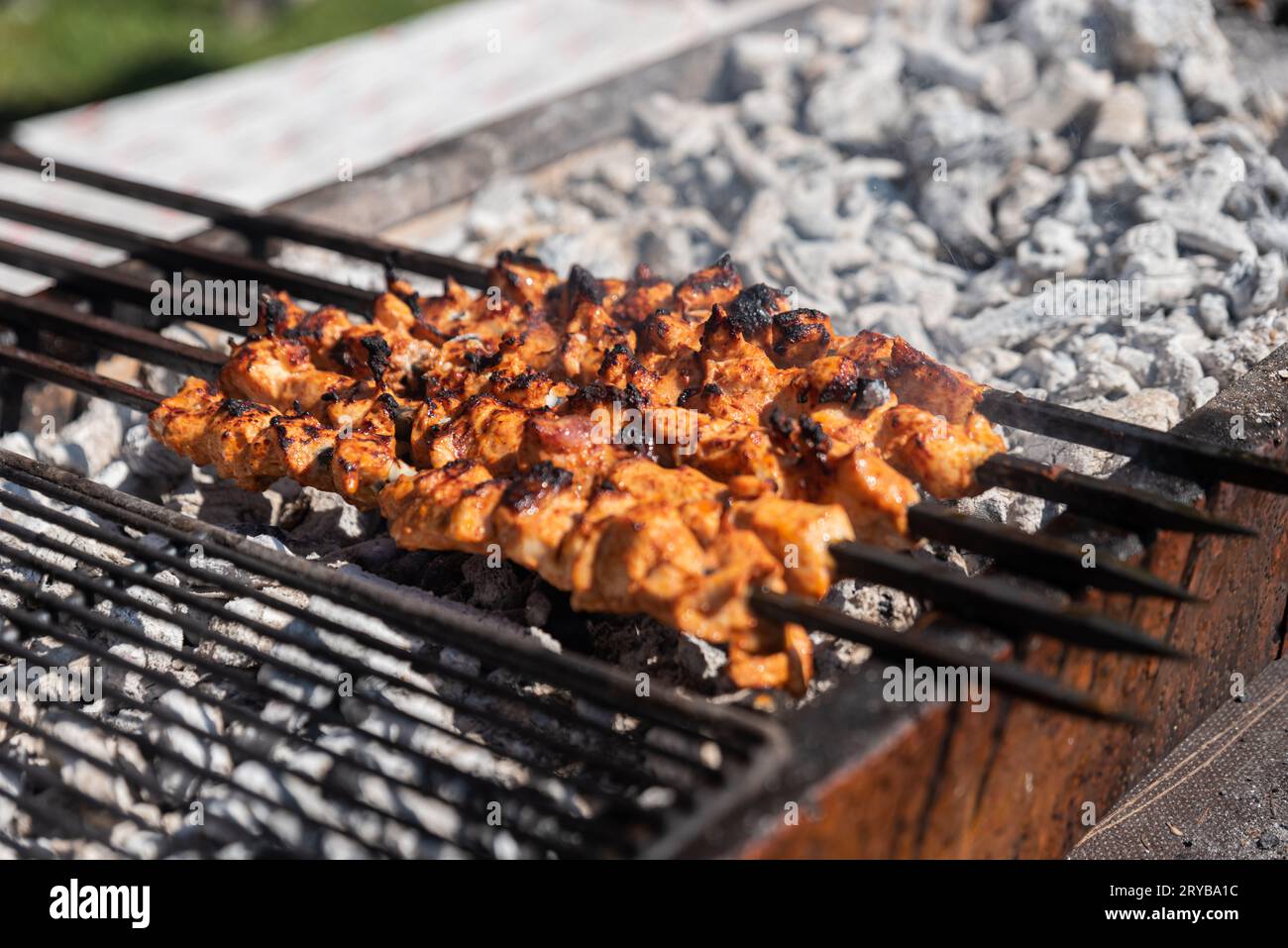 delizioso kebab di pollo alla griglia all'aperto, cucina all'aperto. festival gastronomico in città. gustoso cibo arrostito su spiedini, area ristoro. picnic estivo. Foto Stock