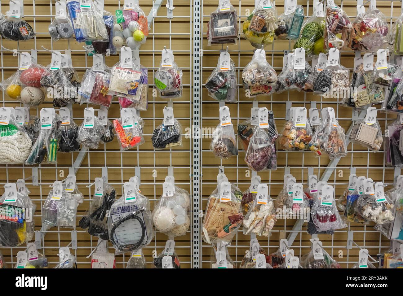 piccoli oggetti casuali in un sacchetto di plastica, appesi a un rack, all'interno di un negozio di articoli da regalo Foto Stock
