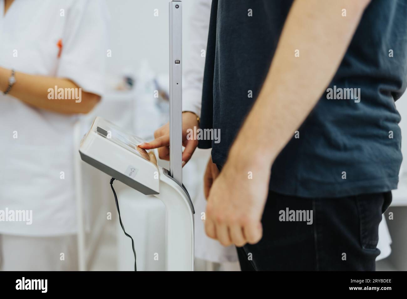 Professionisti medici esperti che effettuano misurazioni dell'altezza con Stadiometro Foto Stock