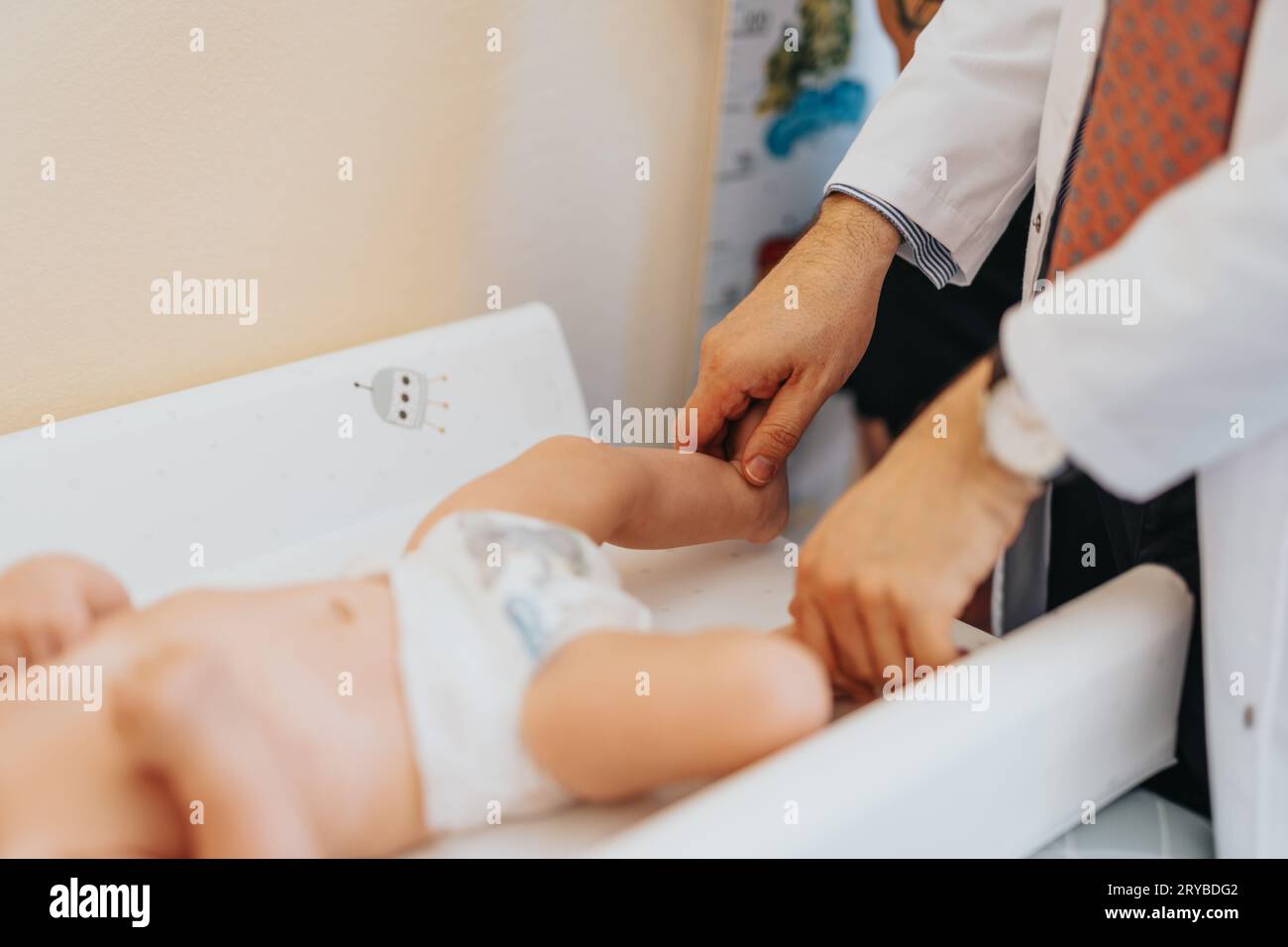 Medico pediatra esperto che esamina il bambino nella clinica moderna. Concetto di assistenza sanitaria per bambini. Foto Stock