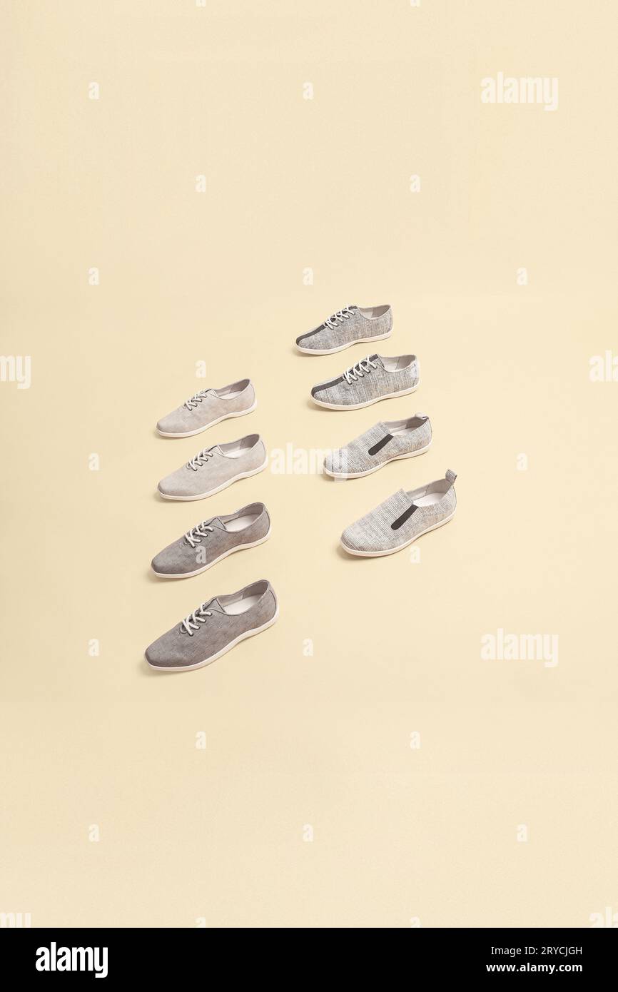 Eleganti sneaker di colore grigio isolate su sfondo beige; spazio per il testo; vista dall'alto Foto Stock