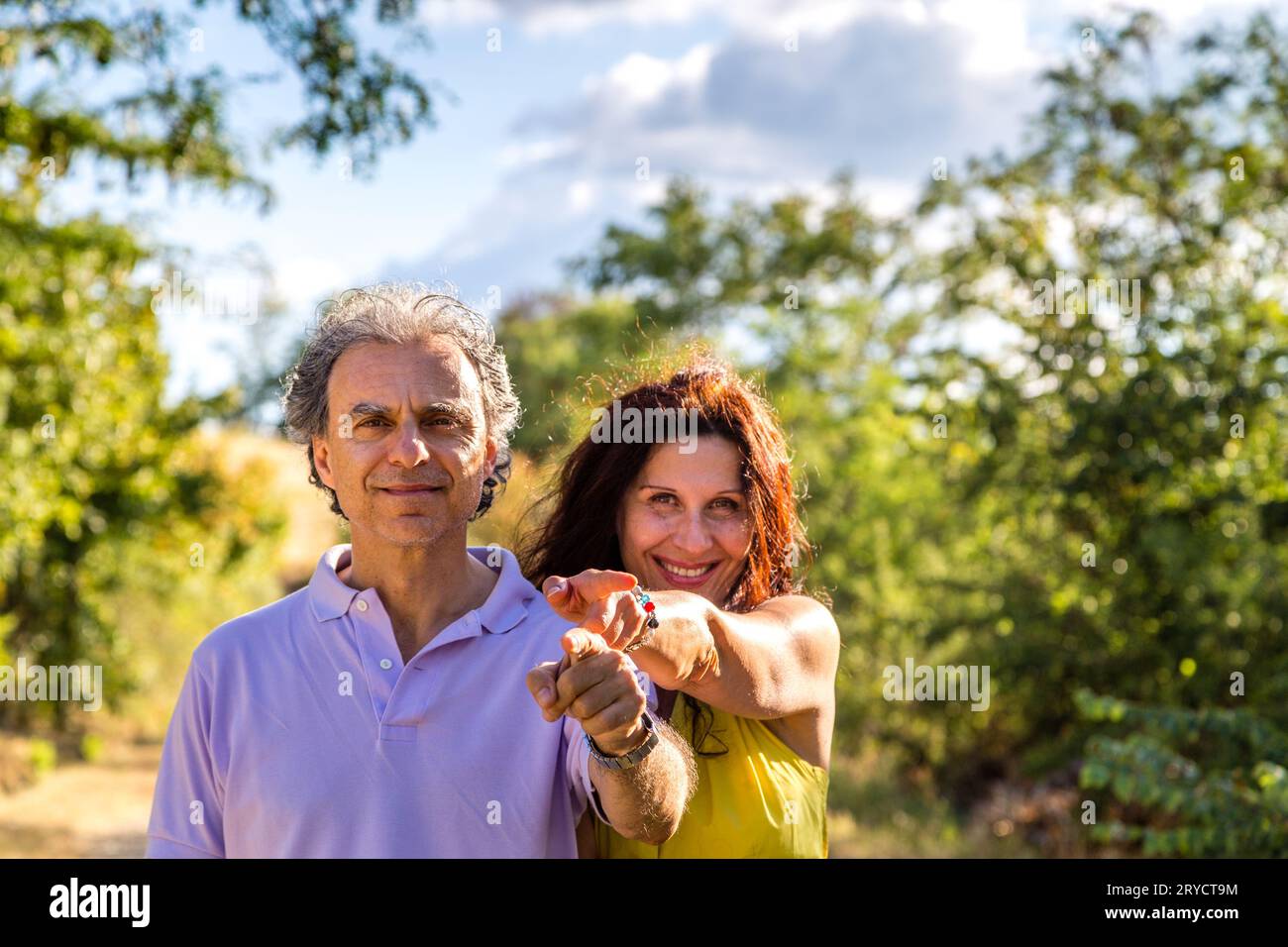 Coppia matura sorridente con le dita puntate Foto Stock