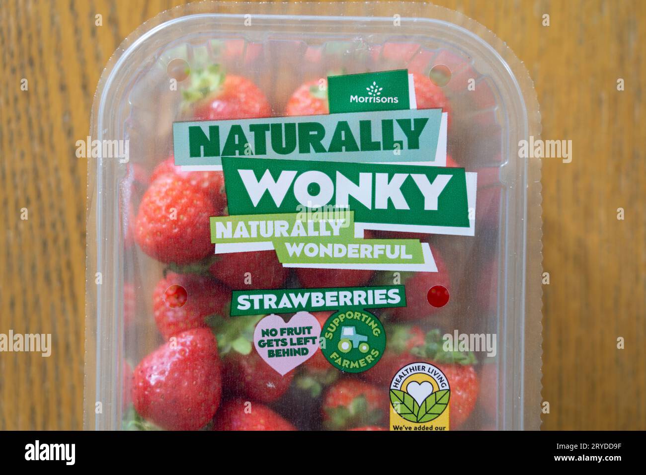 Le fragole di marca del supermercato Morrisons in confezione, etichettate come "naturalmente wonky". Concetto: Cercare di ridurre gli sprechi alimentari del Regno Unito, la frutta e le verdure stravaganti Foto Stock