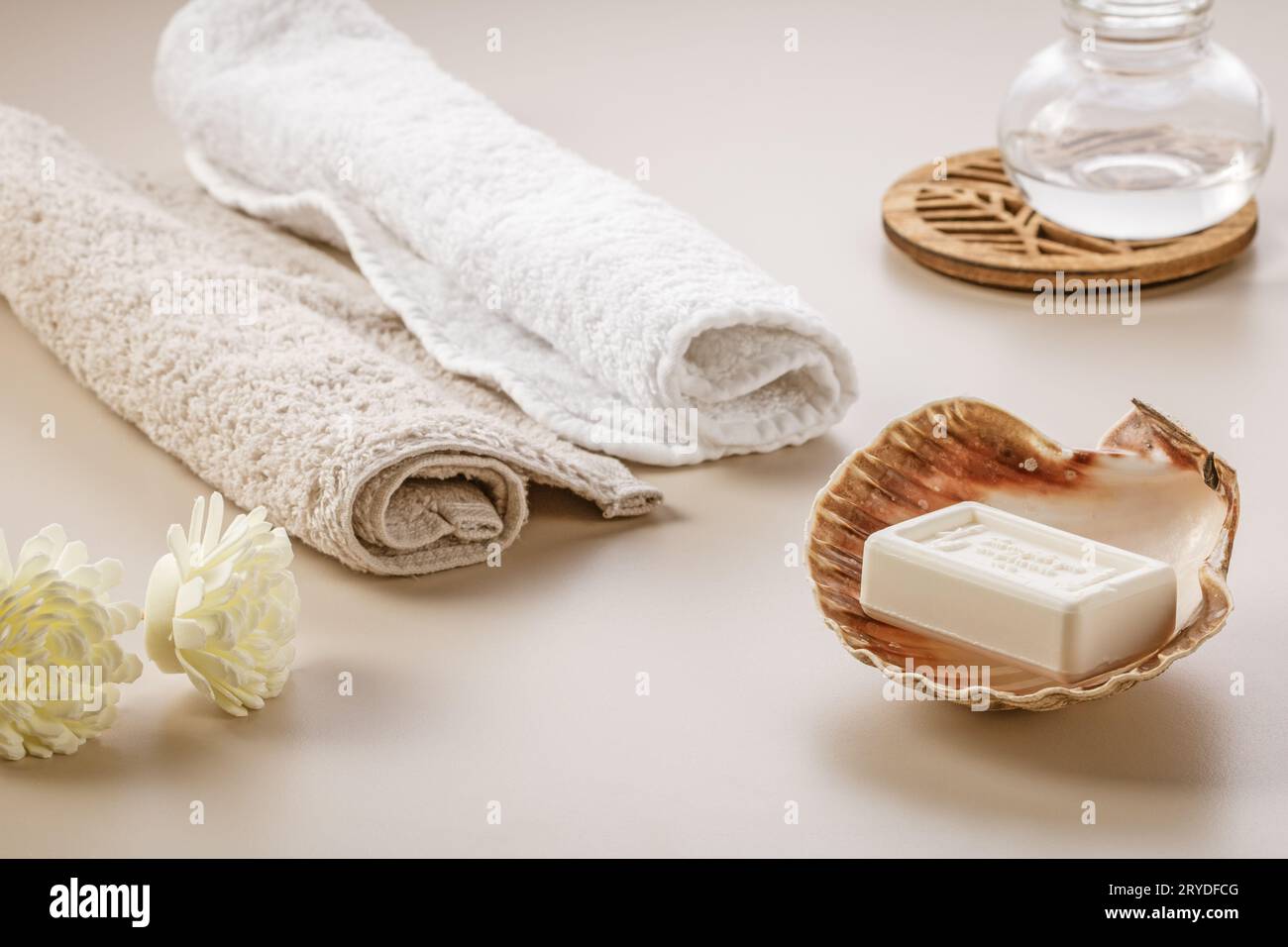 Stile scandinavo minimalista. Due asciugamani morbidi, fiori secchi e una barretta di sapone in una conchiglia sulla toeletta. Foto Stock