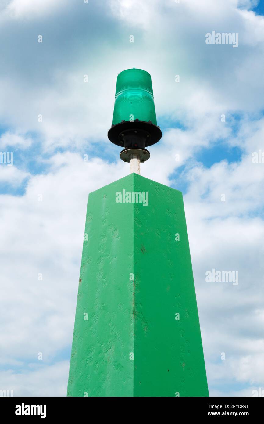 Luce del molo del porto. Luce verde marina con sfondo cielo nuvoloso Foto Stock