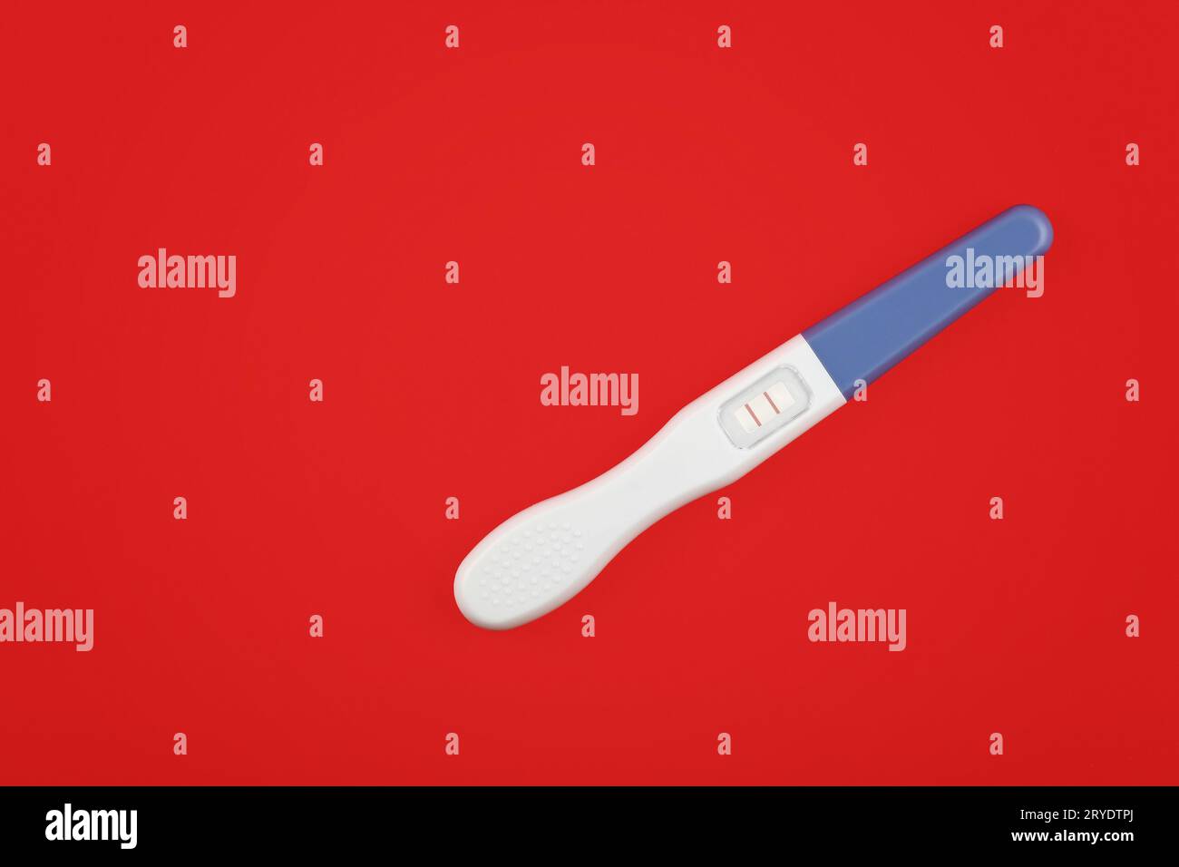 Chiudere il test di gravidanza positivo sul rosso Foto Stock