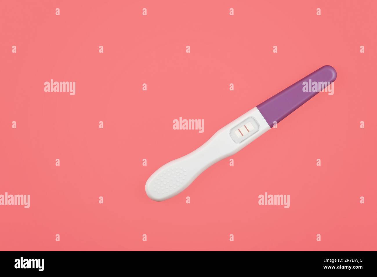 Chiudere il test di gravidanza positivo sul rosa Foto Stock