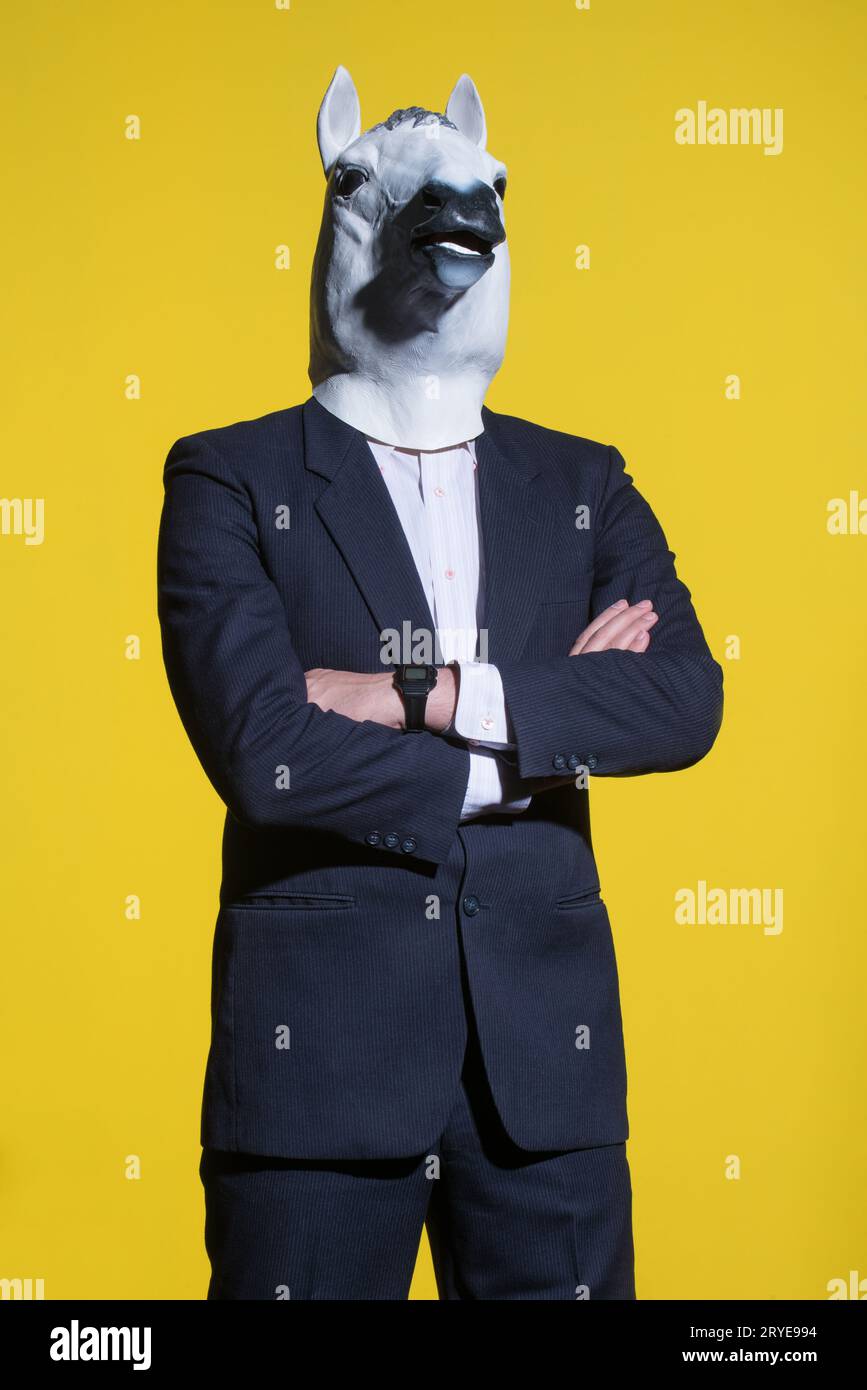 Uomo con maschera di cavallo su sfondo giallo Foto Stock