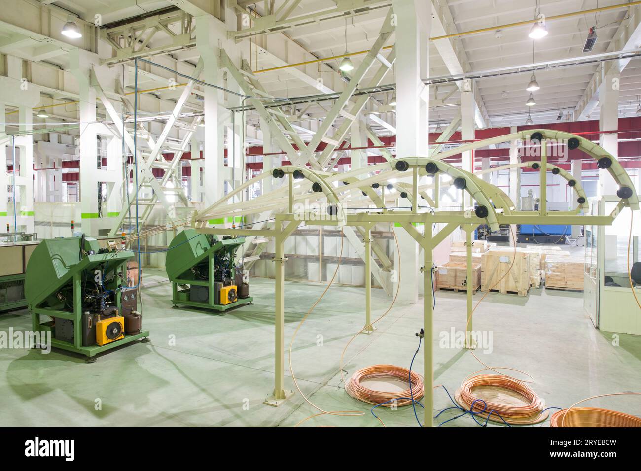In fabbrica attrezzature per la distribuzione di tubi in rame da rulli di taglio e disciplinato da parte dei lavoratori Foto Stock