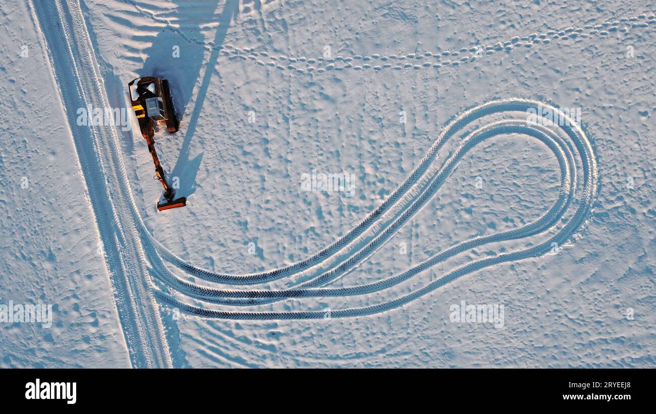 Ripresa aerea con drone dell'escavatore in inverno sulla neve Foto Stock