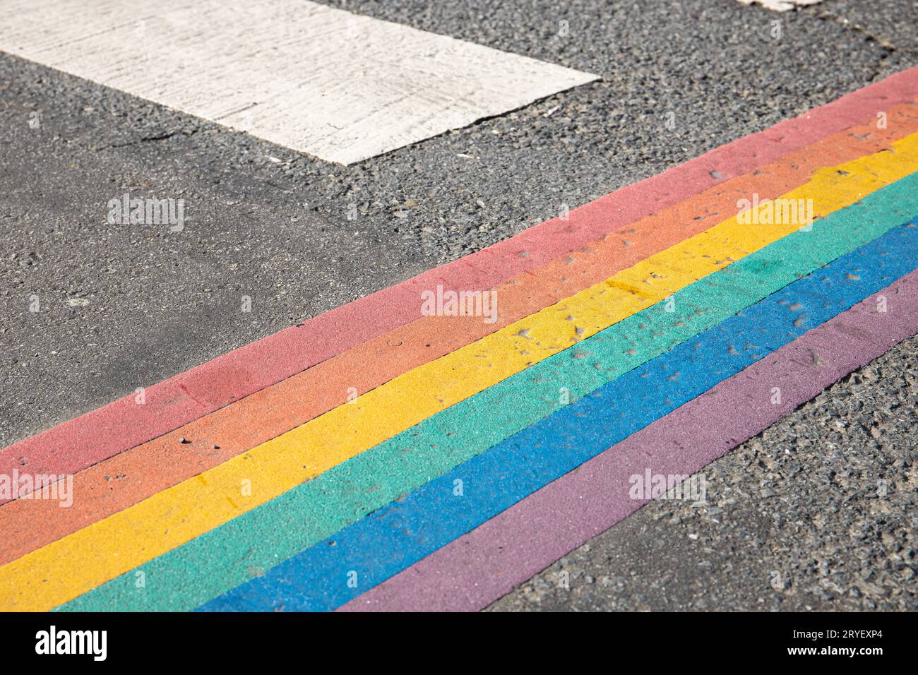 Bandiera dell'arcobaleno, bandiera dell'orgoglio gay o bandiera dell'orgoglio LGBTQ dipinta su asfalto. Decorazione del passaggio della città Foto Stock