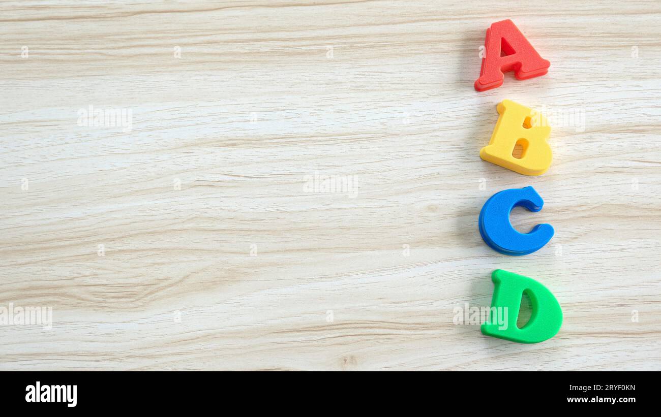 Concetto di istruzione, apprendimento e sviluppo. Alfabeto in legno di ABCD su fondo in legno. Copia spazio. Foto Stock