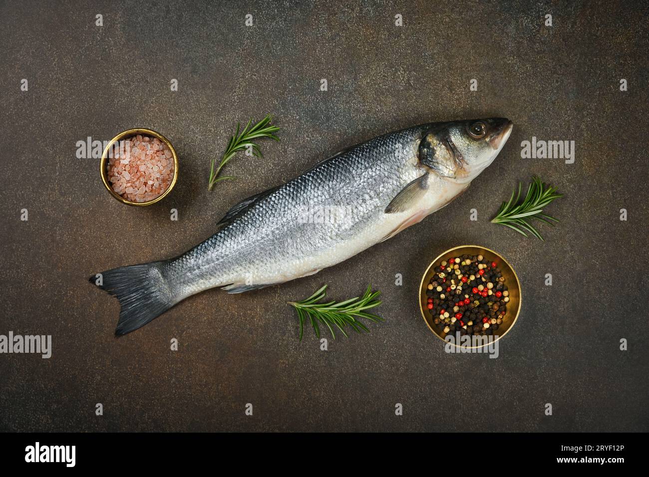 Pesce branzino crudo europeo a tavola Foto Stock