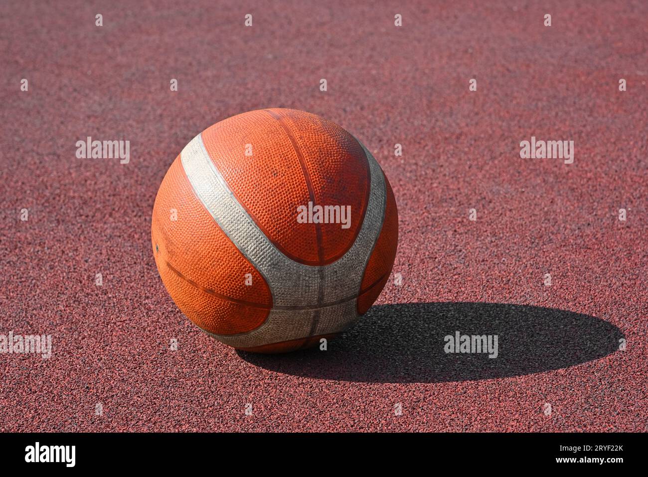 Pallacanestro arancione su un campo rosso all'aperto Foto Stock