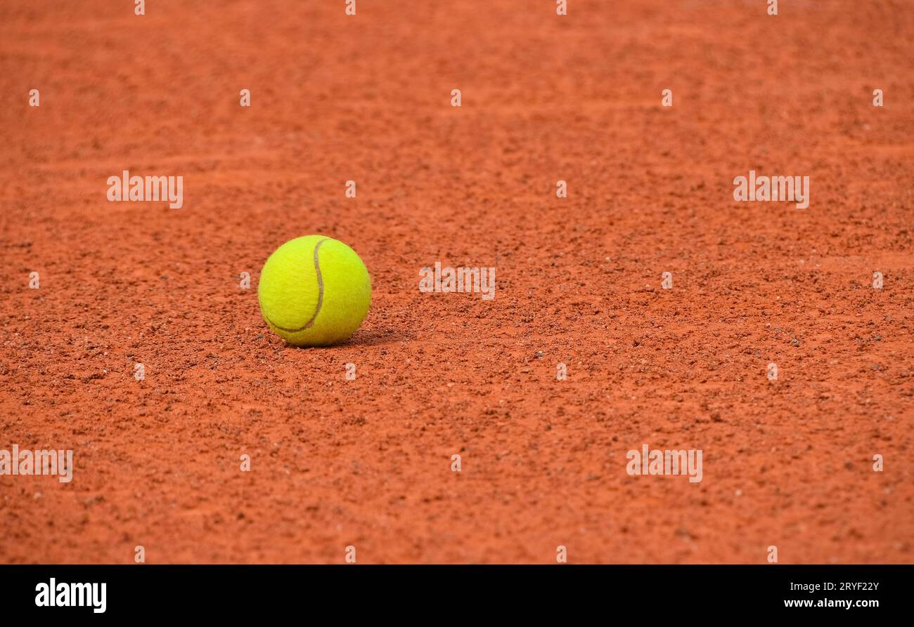 Palla da tennis gialla su campo in terra rossa Foto Stock