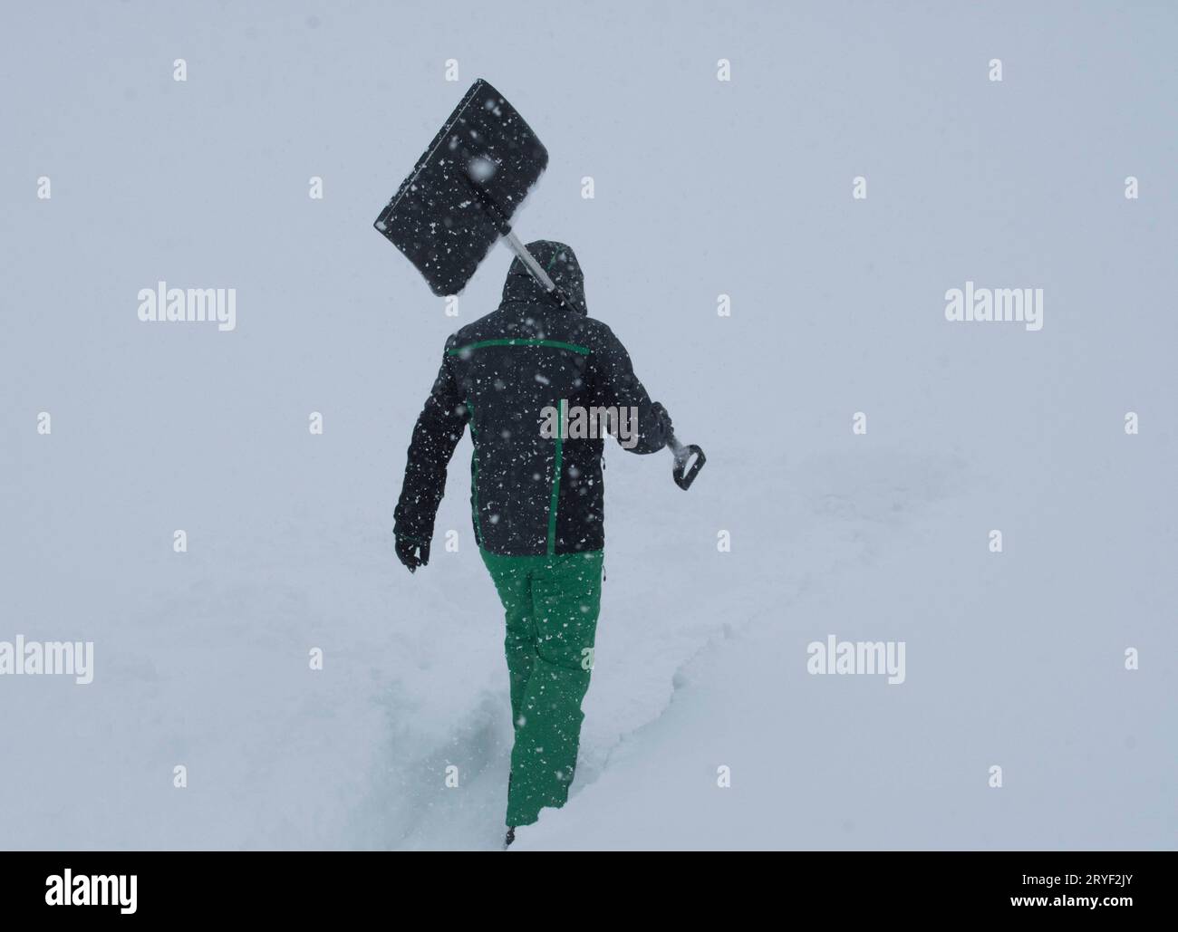 Un uomo spara la neve in una giornata invernale Foto Stock