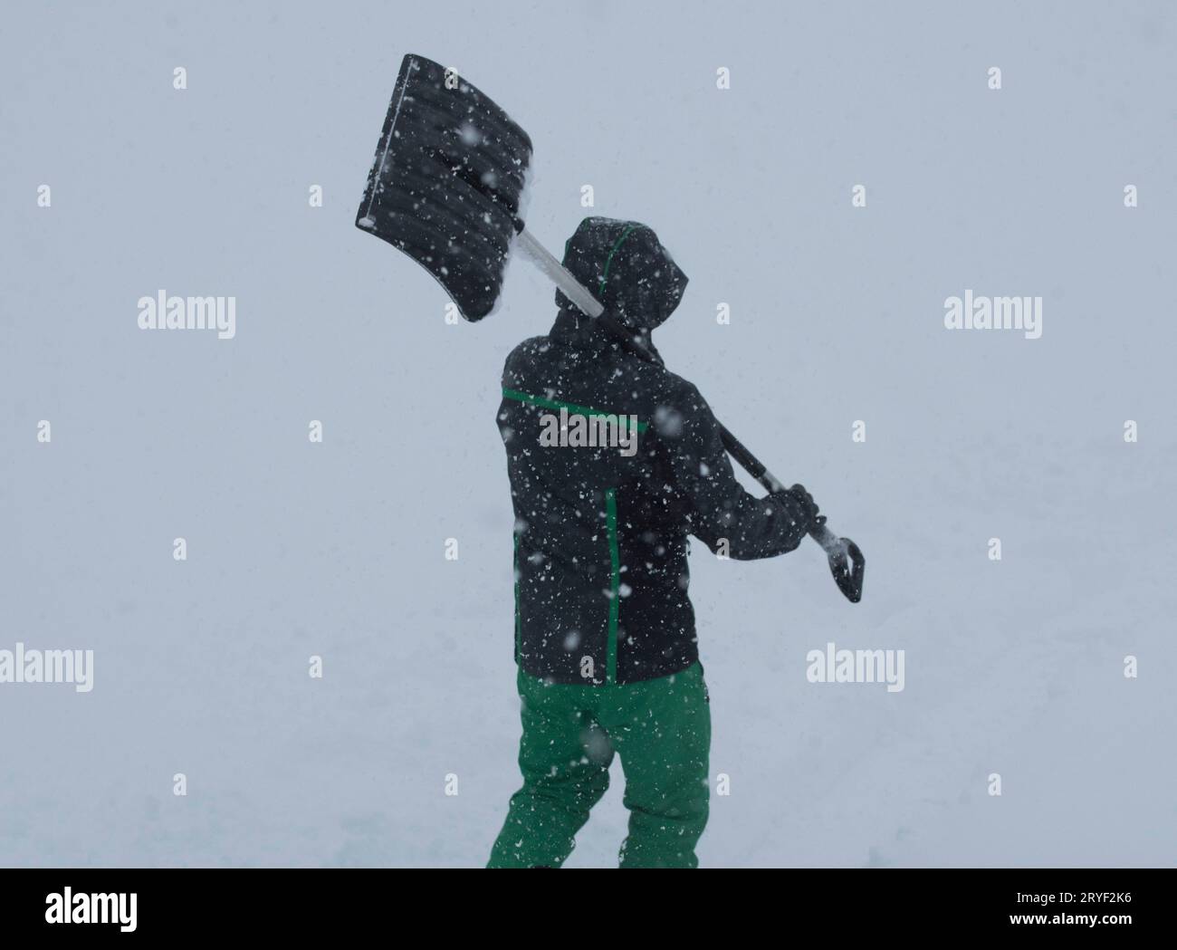 Un uomo spara la neve in una giornata invernale Foto Stock