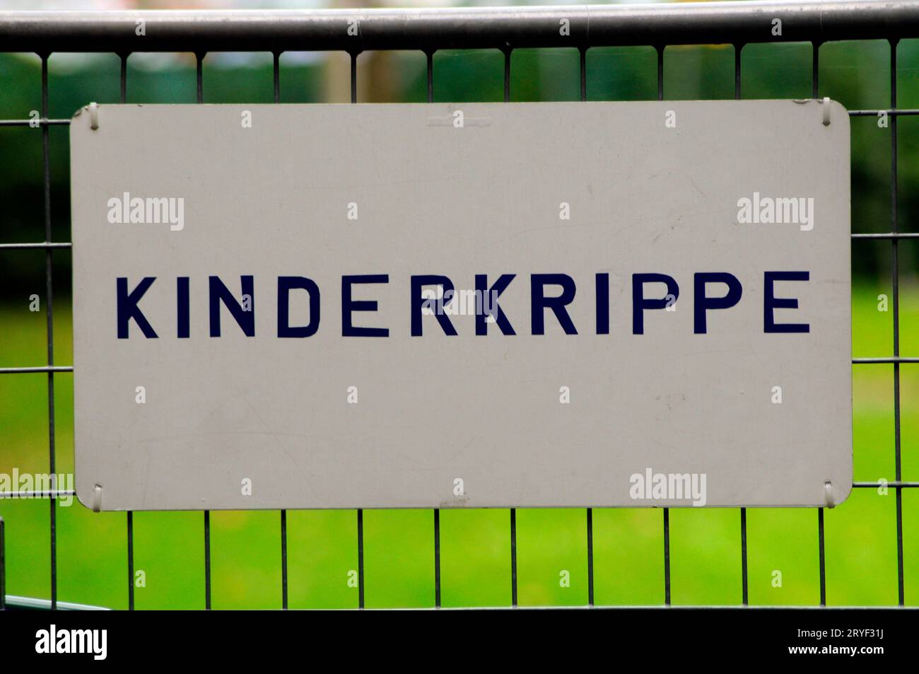 Cartello bianco che indica "Kinderkrippe" (centro di cura dei bambini) Foto Stock