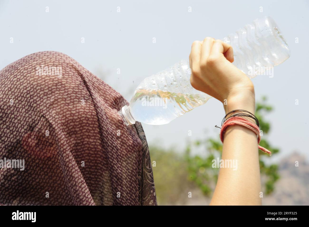 Donna che beve acqua da una bottiglia di plastica Foto Stock