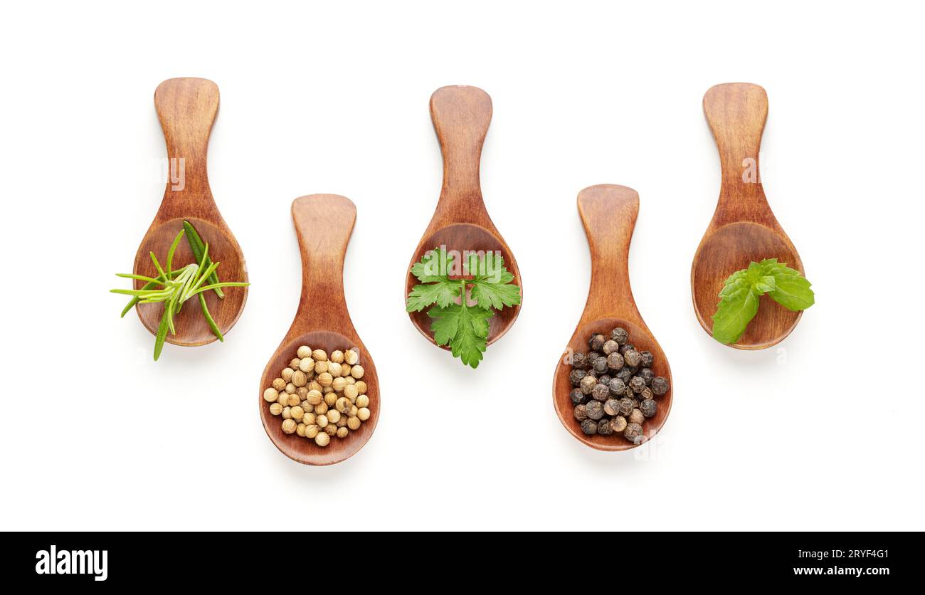 Set di cucchiai con spezie diverse ed erbe culinarie isolate su sfondo bianco. Vista dall'alto Foto Stock