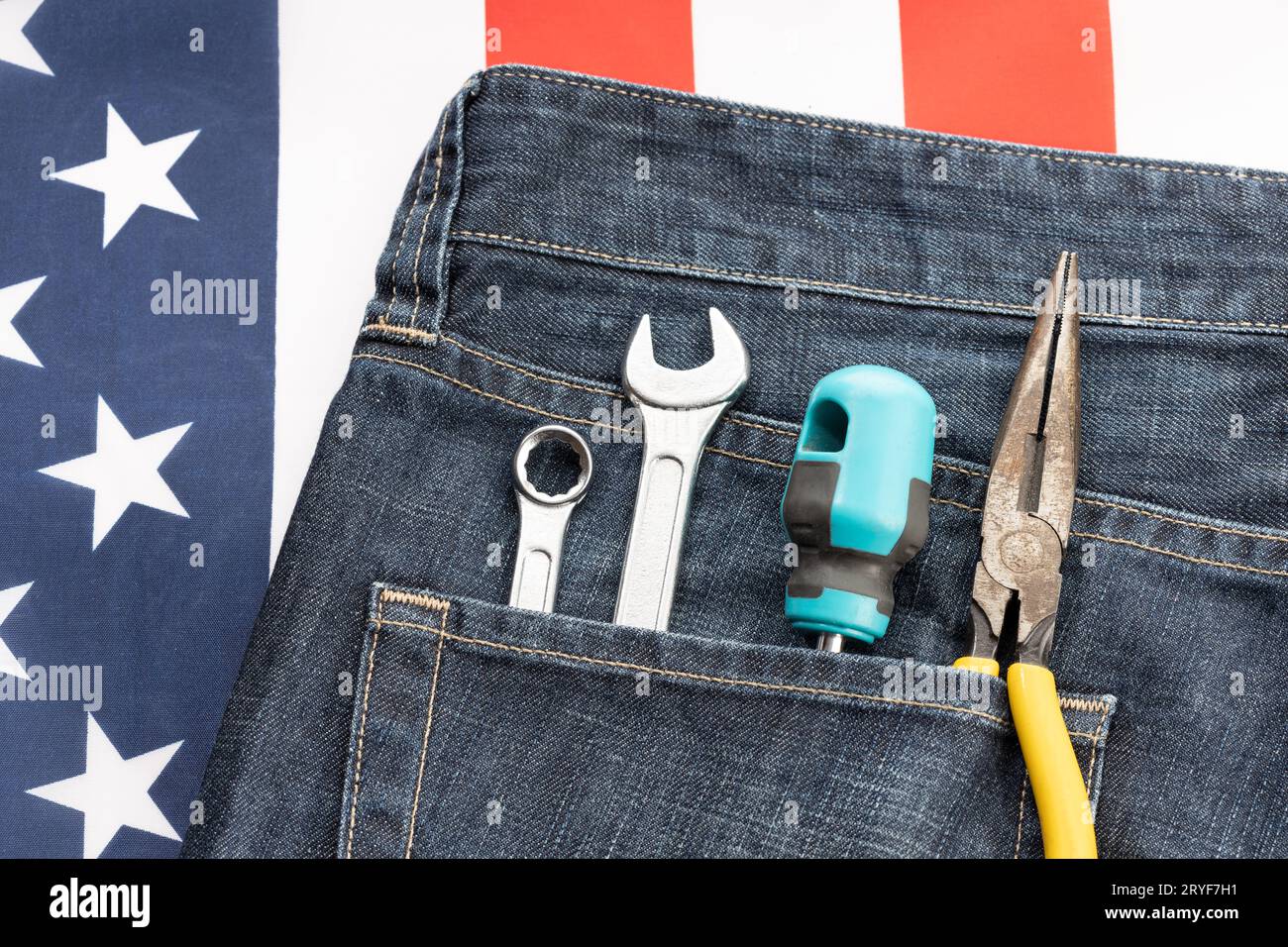 Set di attrezzi in tasca jeans su sfondo bandiera americana. Concetto di background del giorno del lavoro Foto Stock