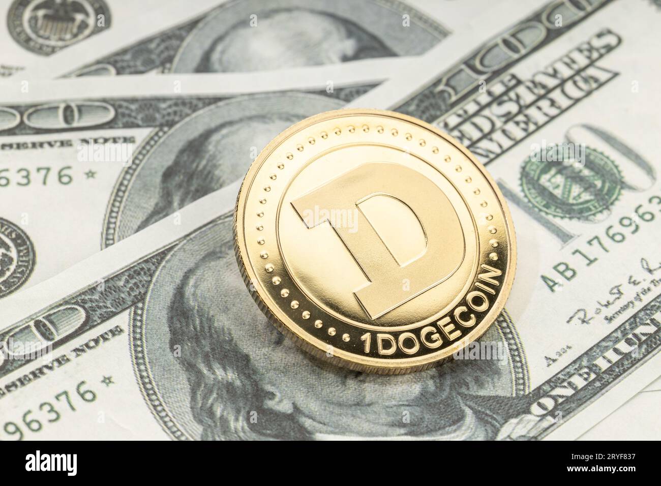 Moneta di Dogecoin sulle banconote in dollari. Criptovaluta sulle bollette del dollaro USA Foto Stock