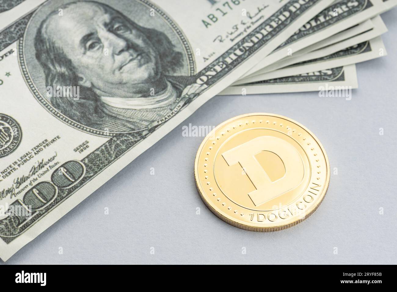 Moneta di Dogecoin sulle banconote in dollari. Criptovaluta sulle bollette del dollaro USA Foto Stock