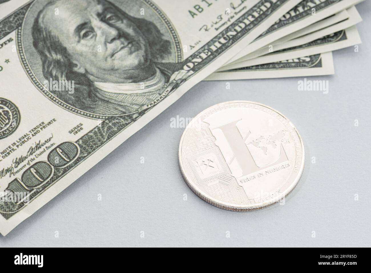 Moneta litecoin e un mucchio di banconote in dollari USA. Blockchain money vs. fiat money Concept Foto Stock
