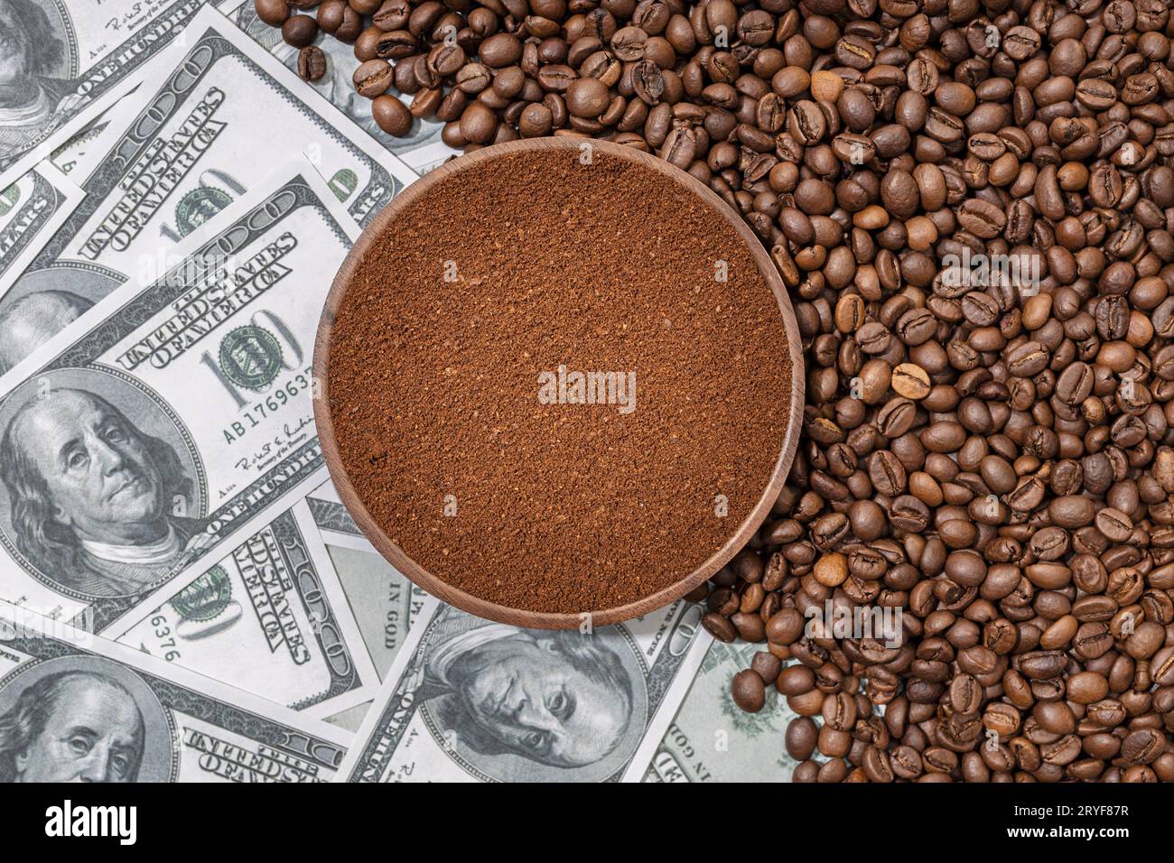 Caffè macinato in una piastra di legno isolata su chicchi di caffè e banconote in dollari di fondo. Vista dall'alto Foto Stock