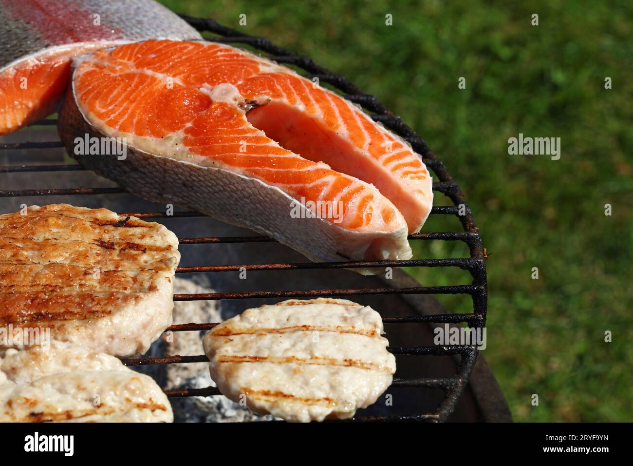 Hamburger di pollo o tacchino e bistecca di salmone alla griglia Foto Stock