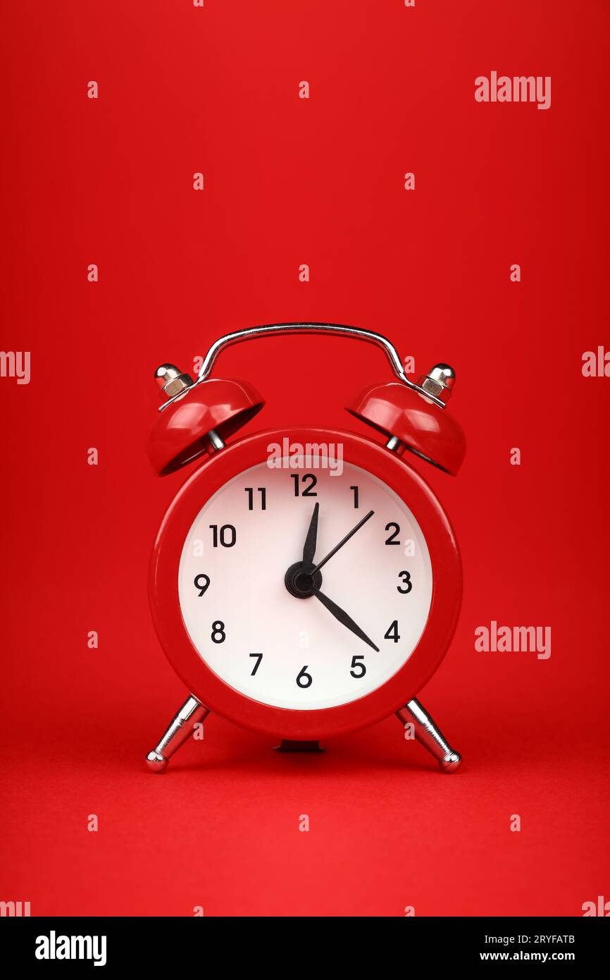 Primo piano di una sveglia rossa su sfondo rosso Foto Stock