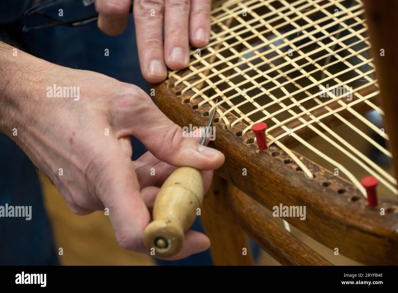 Tessitura del cestello in un'officina riparata Foto Stock