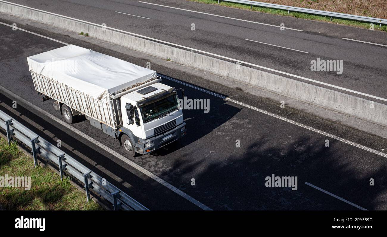 Carrello su strada con contenitore trasparente. Concetto di trasporto merci. Spazio di copia Foto Stock