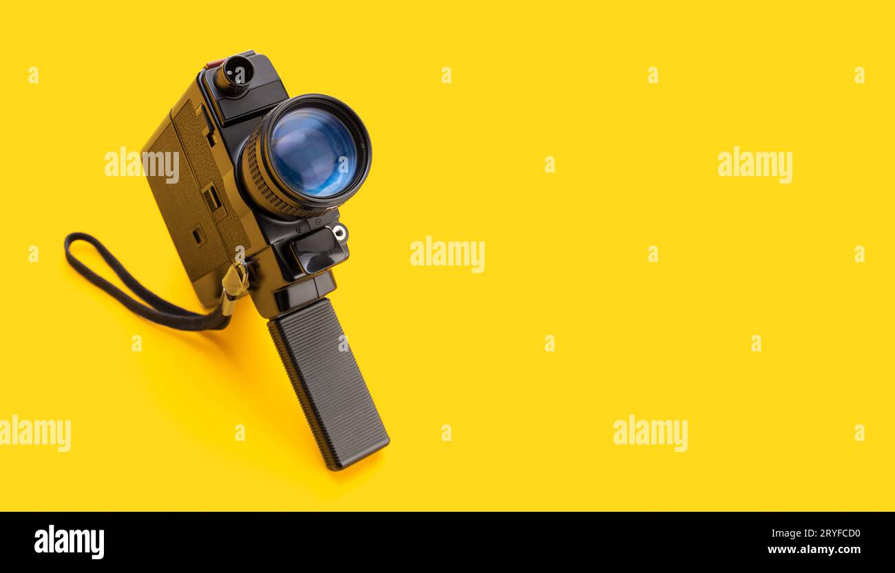 Videocamera Super 8 film isolato su sfondo giallo. Sfondo del cinema. Spazio di copia Foto Stock