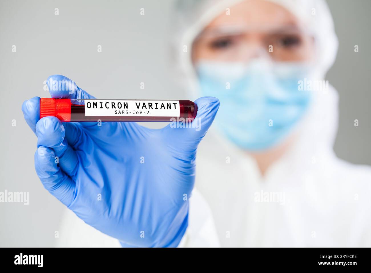Medico che detiene il portacampioni per provette contenenti Omicron variante Coronavirus patie Foto Stock