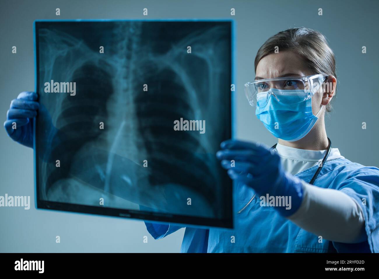 Medico di sesso femminile che guarda la radiografia a raggi X nella stanza del paziente Foto Stock