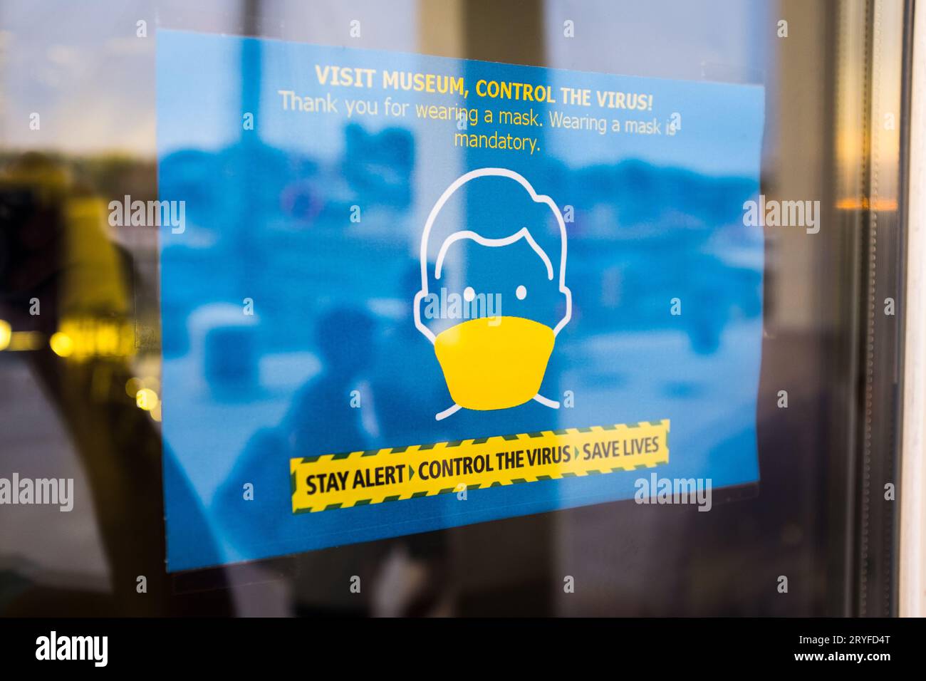 Un cartello blu con la finestra del museo informa le persone che è obbligatorio indossare una maschera protettiva Foto Stock