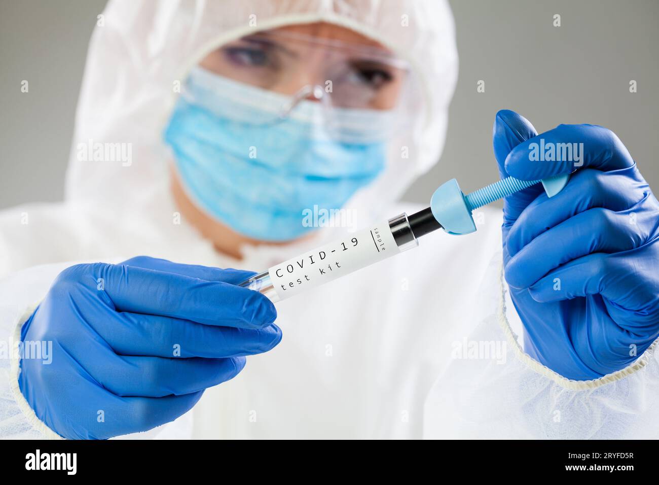 Lavoratrice medica femminile che detiene il kit di test COVID-19 Foto Stock