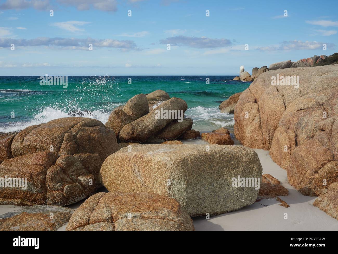 Bay of Fires Tasmania, con oceano turchese. Il cielo è blu profondo e la costa è costeggiata da rocce cariche di licheni con un po' di vegetazione. Foto Stock