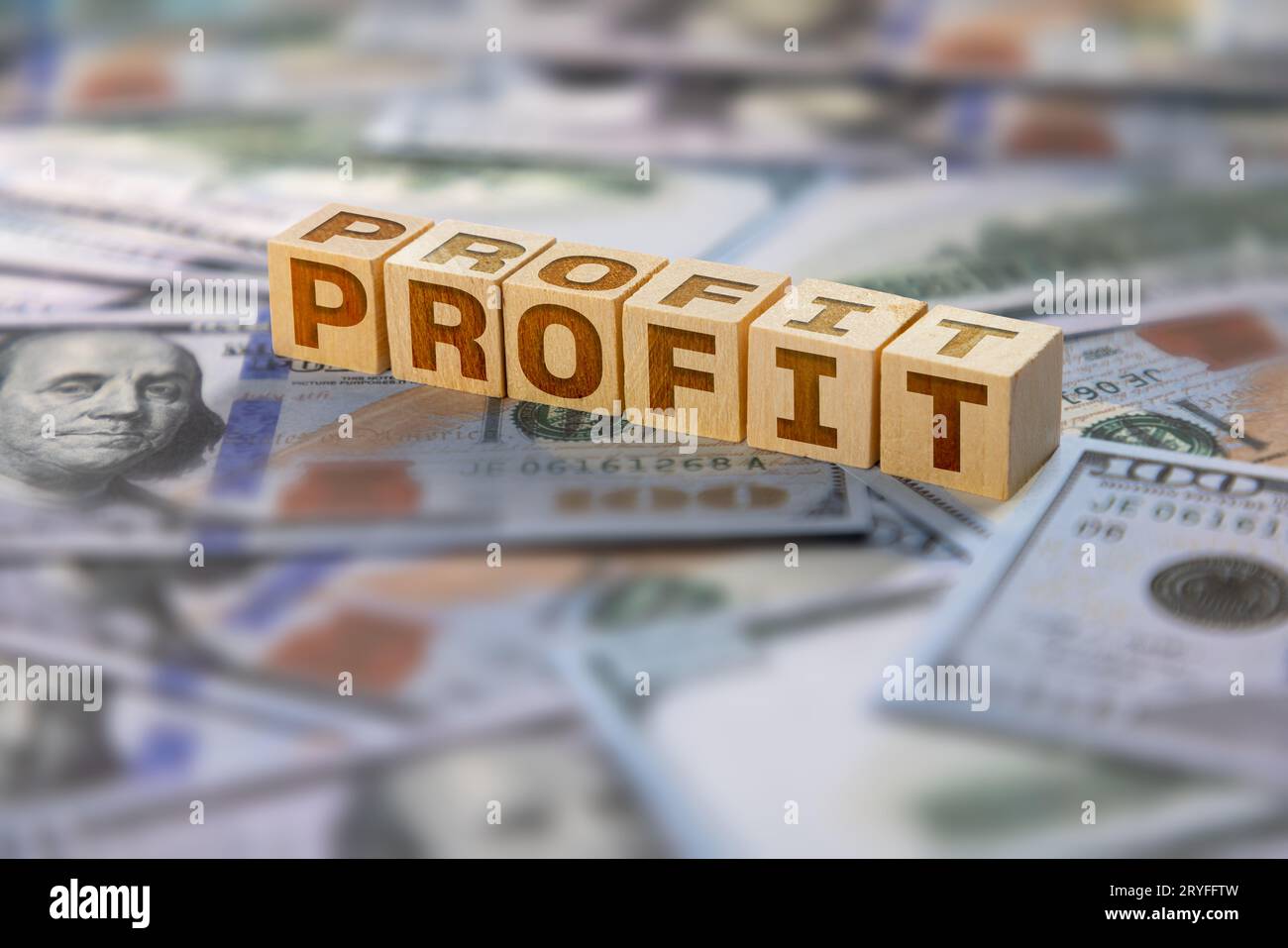 Testo del profitto scritto su blocchi di legno con banconote americane sullo sfondo Foto Stock