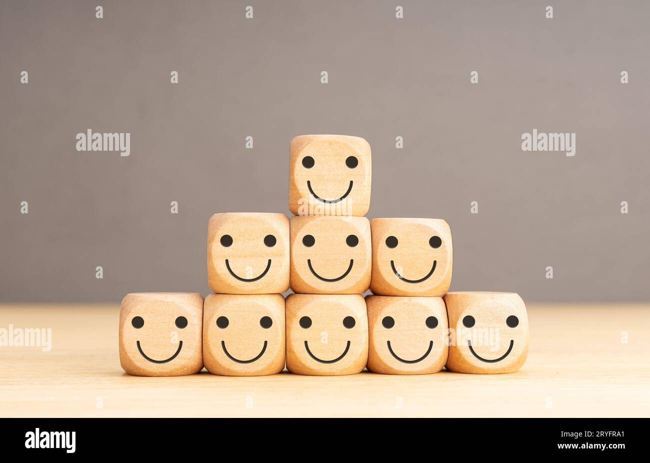 Eccellente servizio di affari che classifica l'esperienza del cliente. Mano mettendo a forma di blocco di legno con icona faccia sorridente Foto Stock