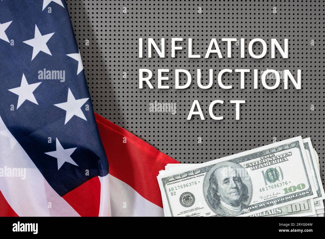 Legge sulla riduzione dell'inflazione. Lay grasso di testo, bandiera americana e banconote in dollari Foto Stock