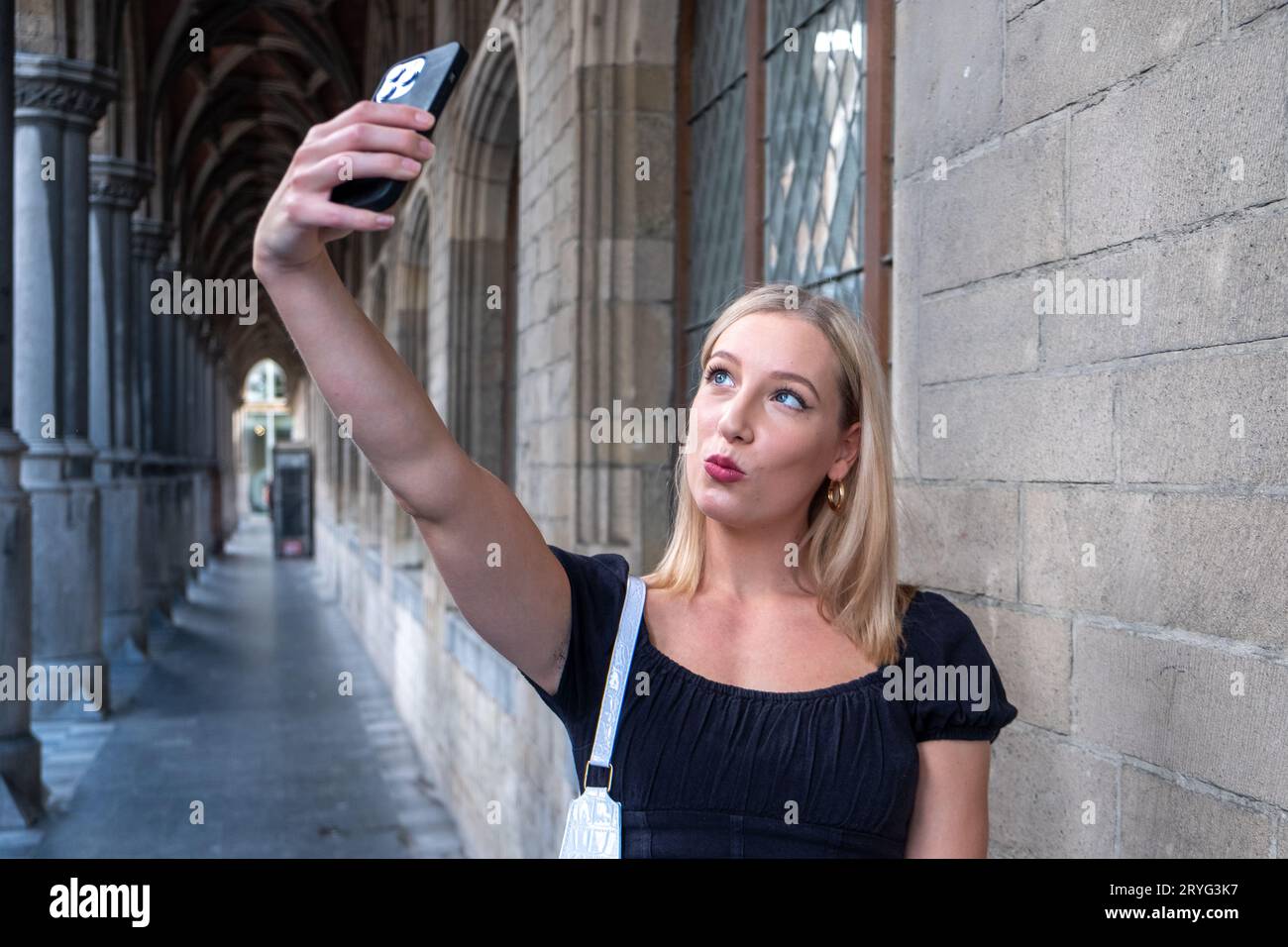 Ritratto di un meraviglioso modello femminile bianco con un trucco luminoso che esprime energia in una buona giornata in Europa. Adorabile donna bionda in stile Foto Stock